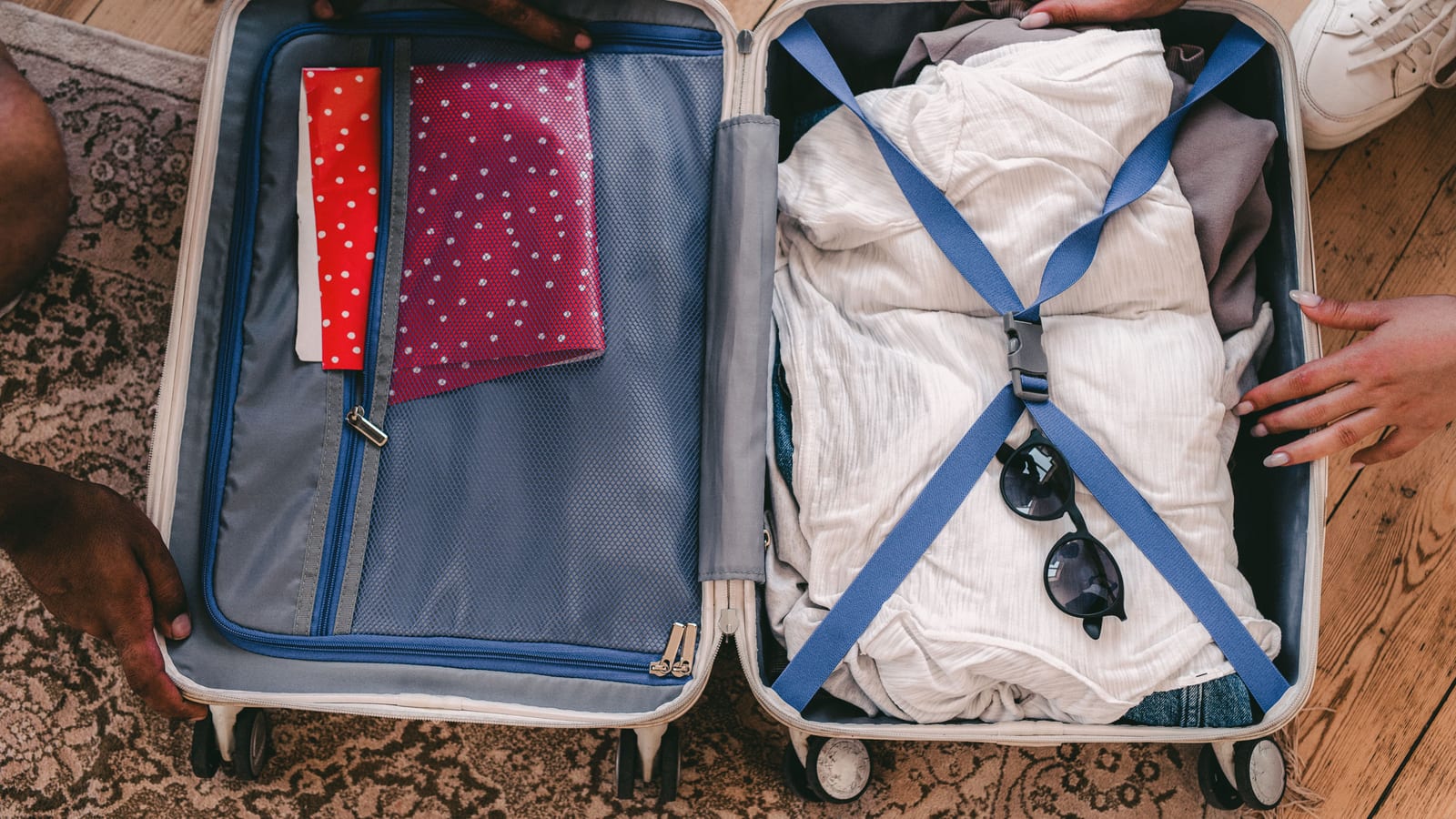 A neatly packed open suitcase with clothing and travel essentials, ready for a trip.