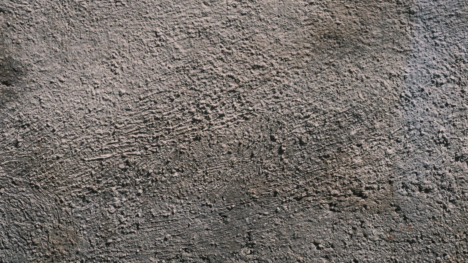 Close-up of a rough textured concrete wall providing a gray solid surface ideal for backgrounds.